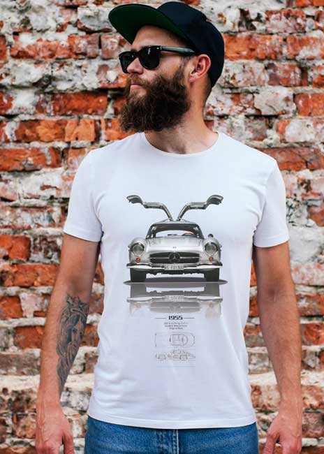 Man in car print t-shirt, brick wall background.