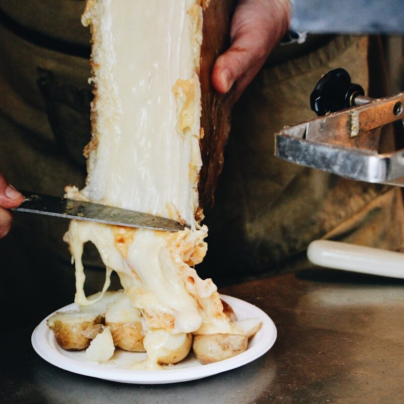 a person cutting a piece of cake with a knife