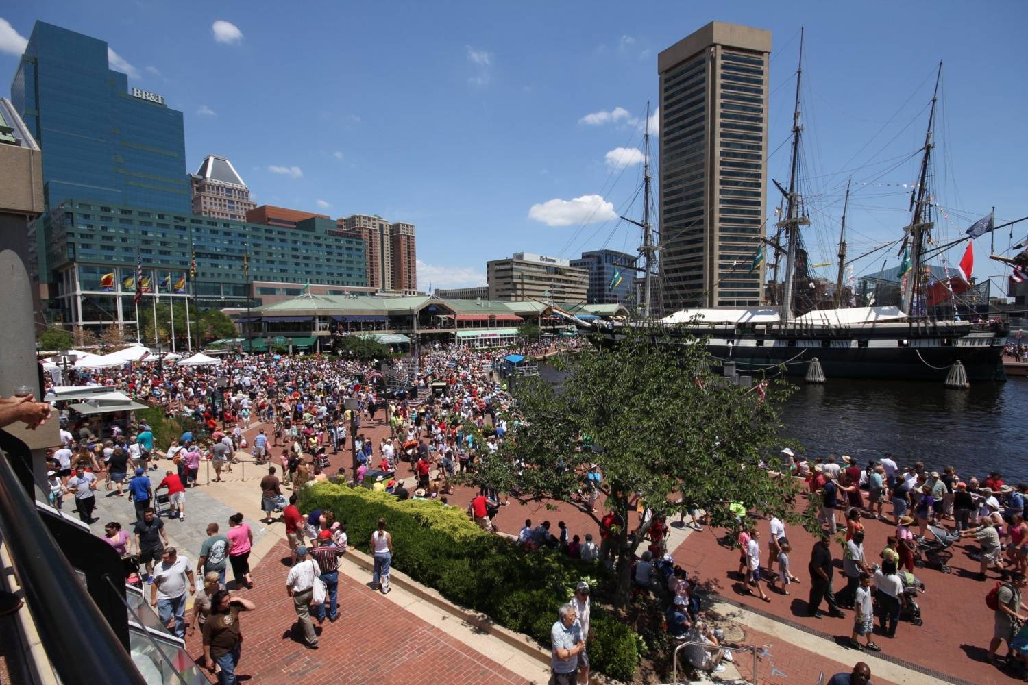 A crowd of people gathered on a sidewalk in front of a building.