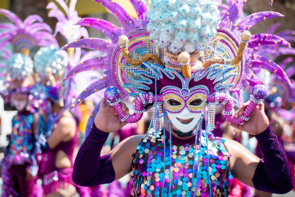 A group of people dressed in purple and blue costumes at Power Plant Live during Mardi Gras.