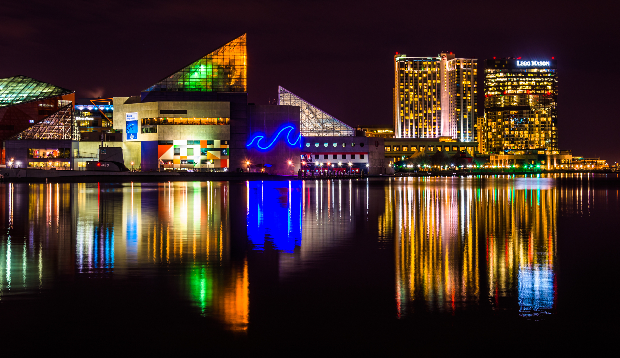 November's Fun-Filled Adventures Near Harbor Park Garage! A city building stands tall, mirrored in the tranquil waters nearby.