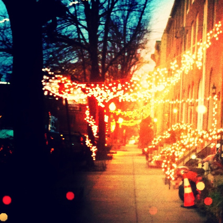 A Federal Hill sidewalk in Baltimore with lights on it.