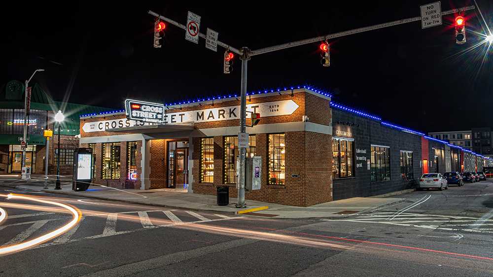 A Federal Hill street scene illuminated by holiday lights, with a building in the background.