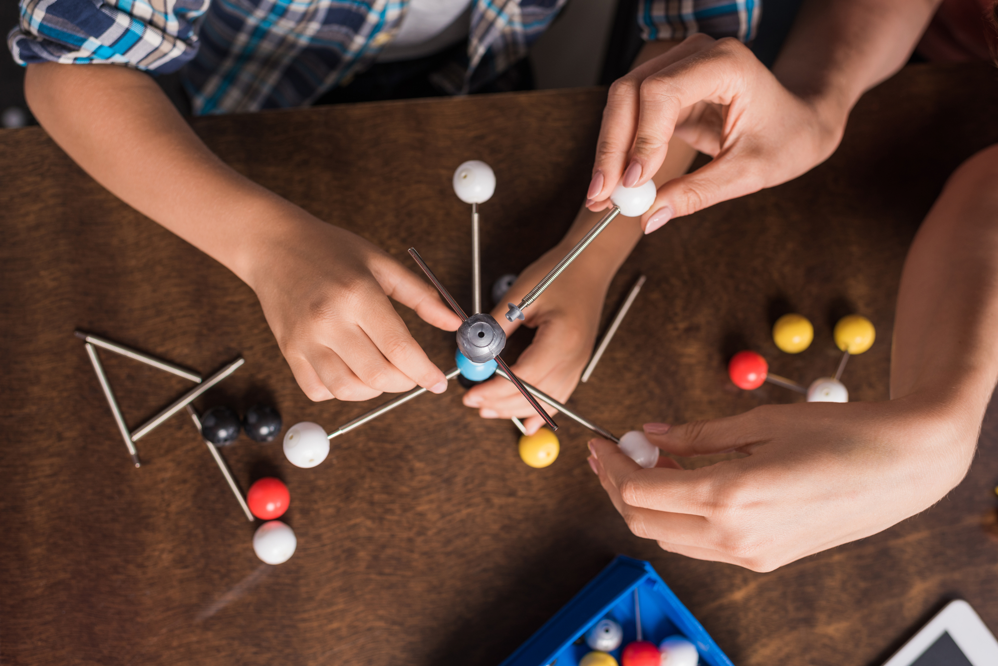 A man and a woman working on a model of a molecule at Harbor Park Garage.