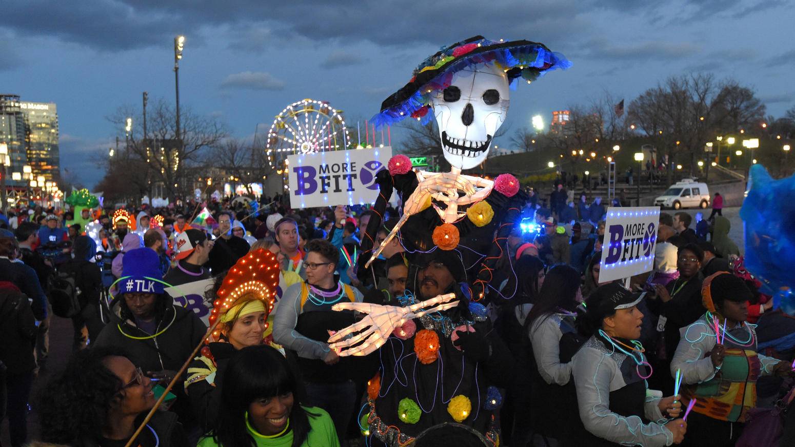 A group of people dressed as skeletons walk down a street.