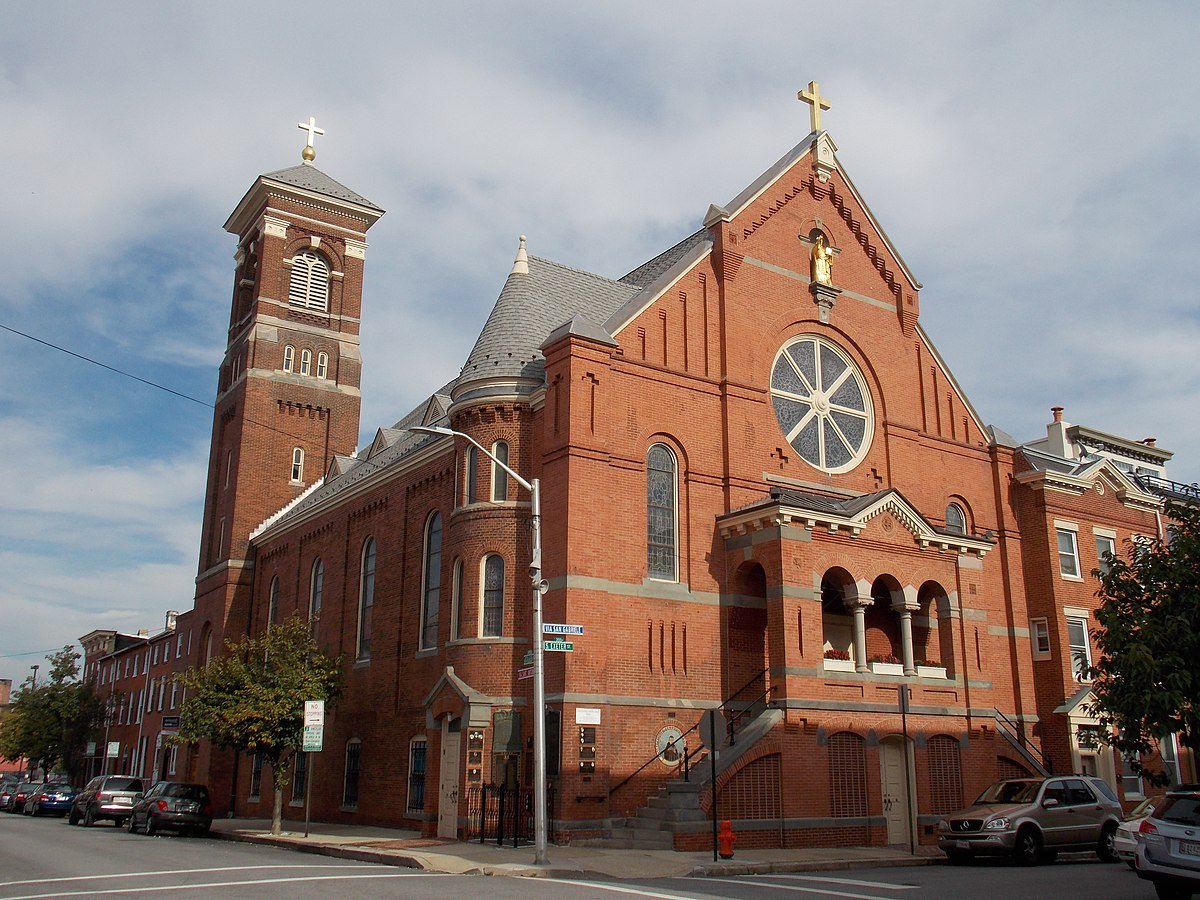 A festive red brick building with a clock tower in Little Italy, Baltimore.