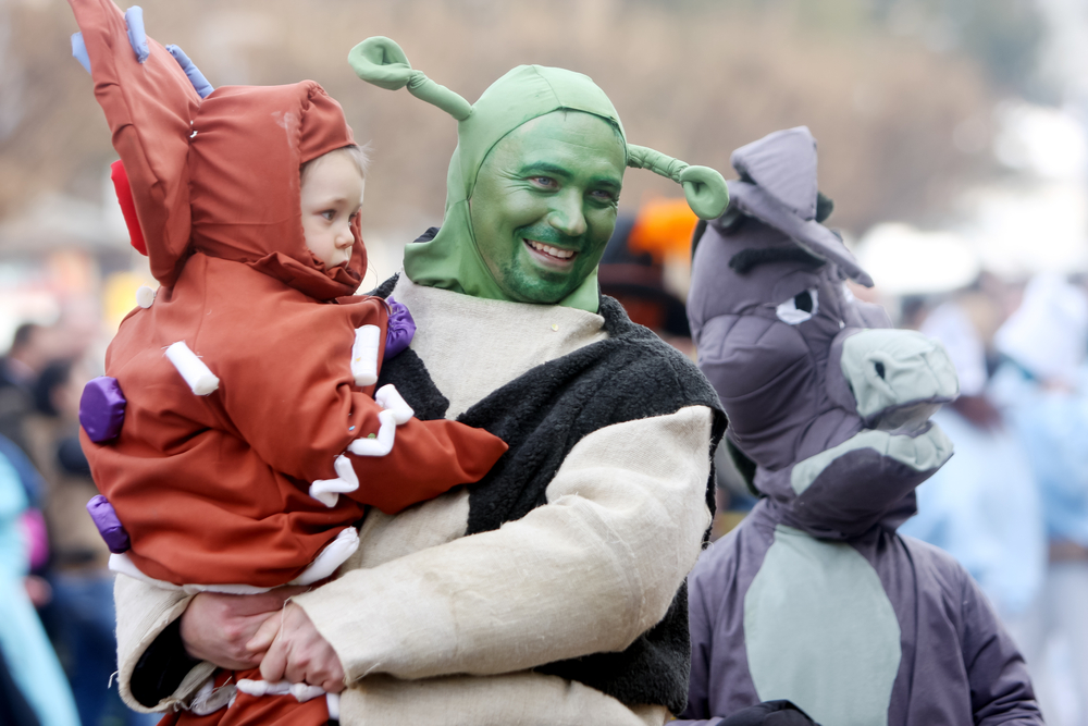 A man holding a child in a Shrek costume at Baltimore Soundstage rave.