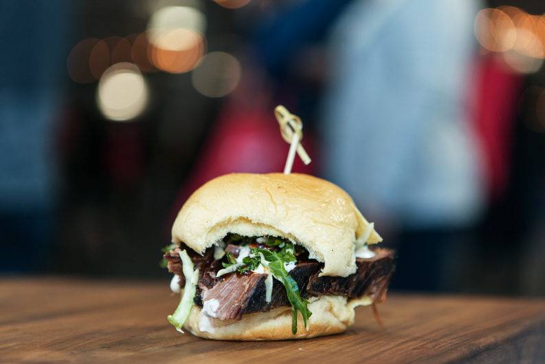 A burger sitting on a wooden table.